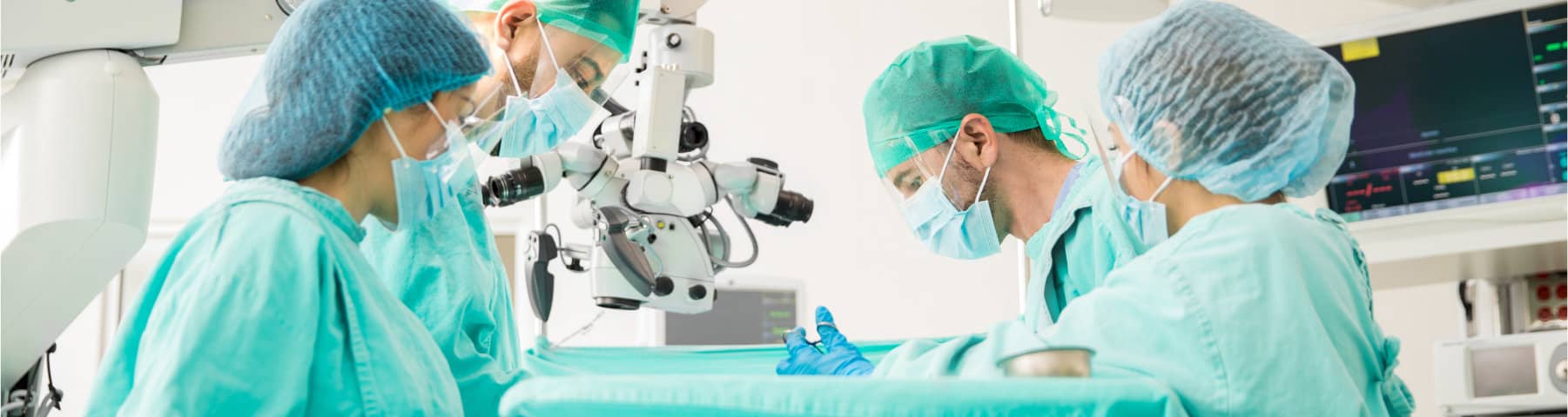 Surgeons in protective gowns and masks perform a surgical procedure in an operating room