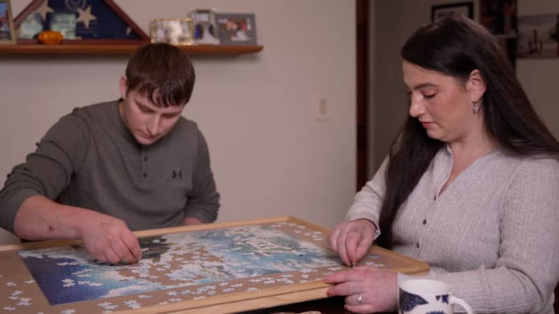 Paige Glennerster work on a puzzle with her partner.